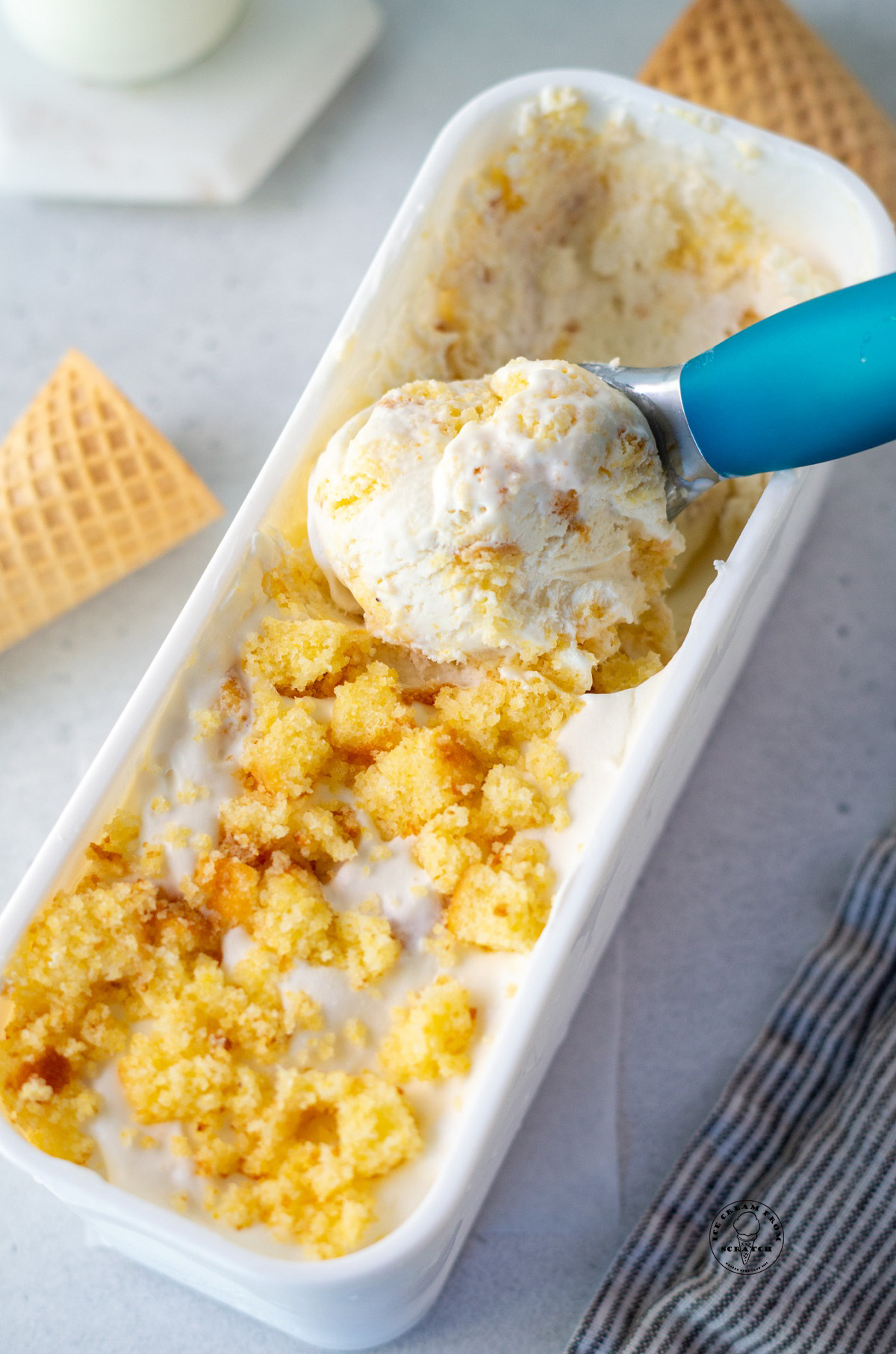 a long white rectangular container of ice cream topped with cornbread crumbles.