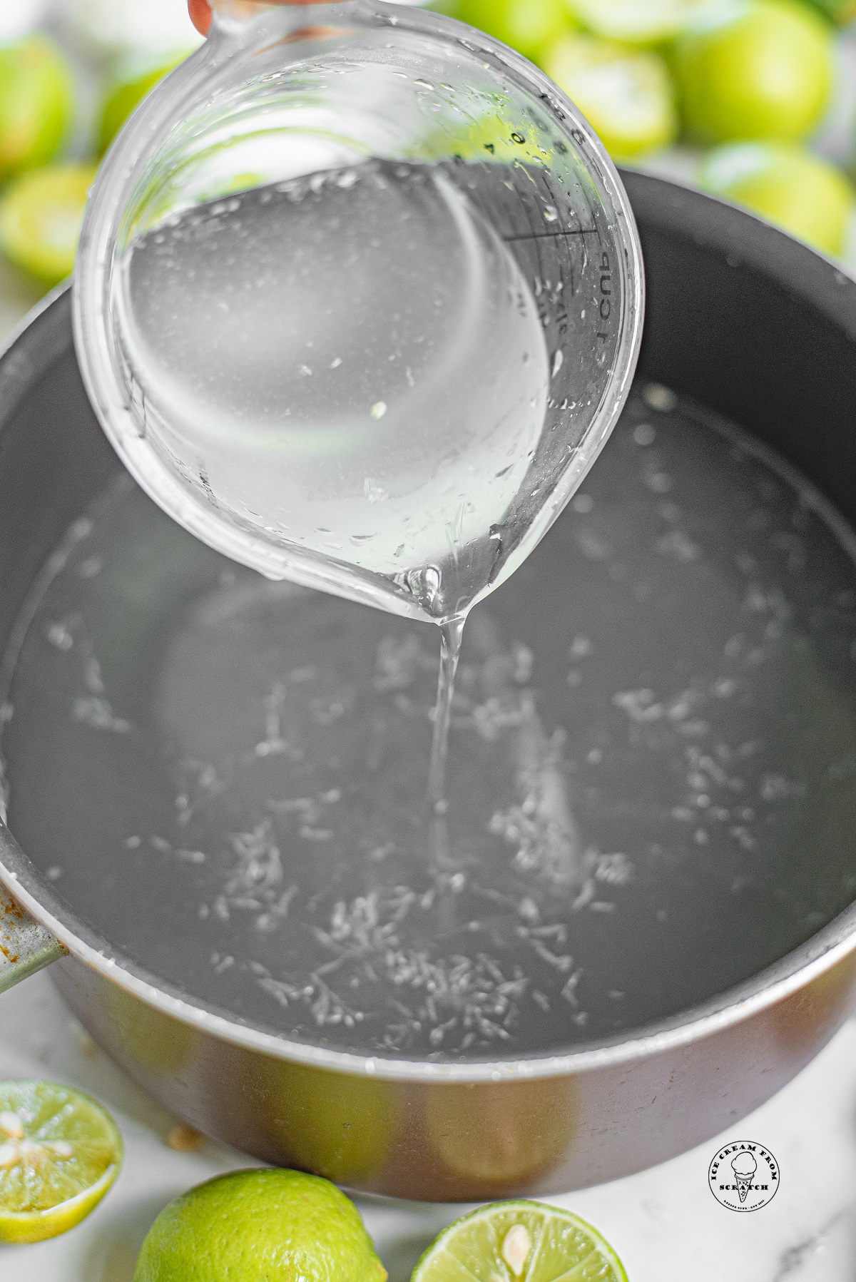 a pitcher pouring water into a saucepan.