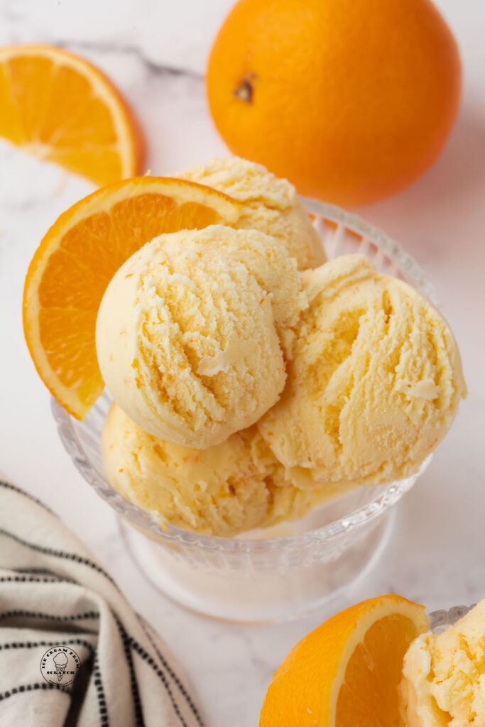 scoops or orange creamsicle ice cream in a footed dish