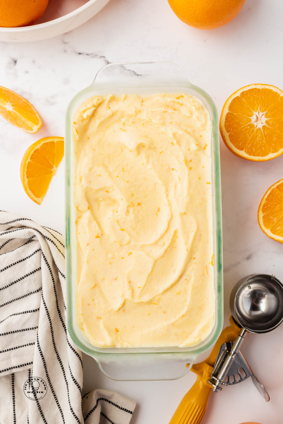 orange creamsicle ice cream in a glass loaf pan.