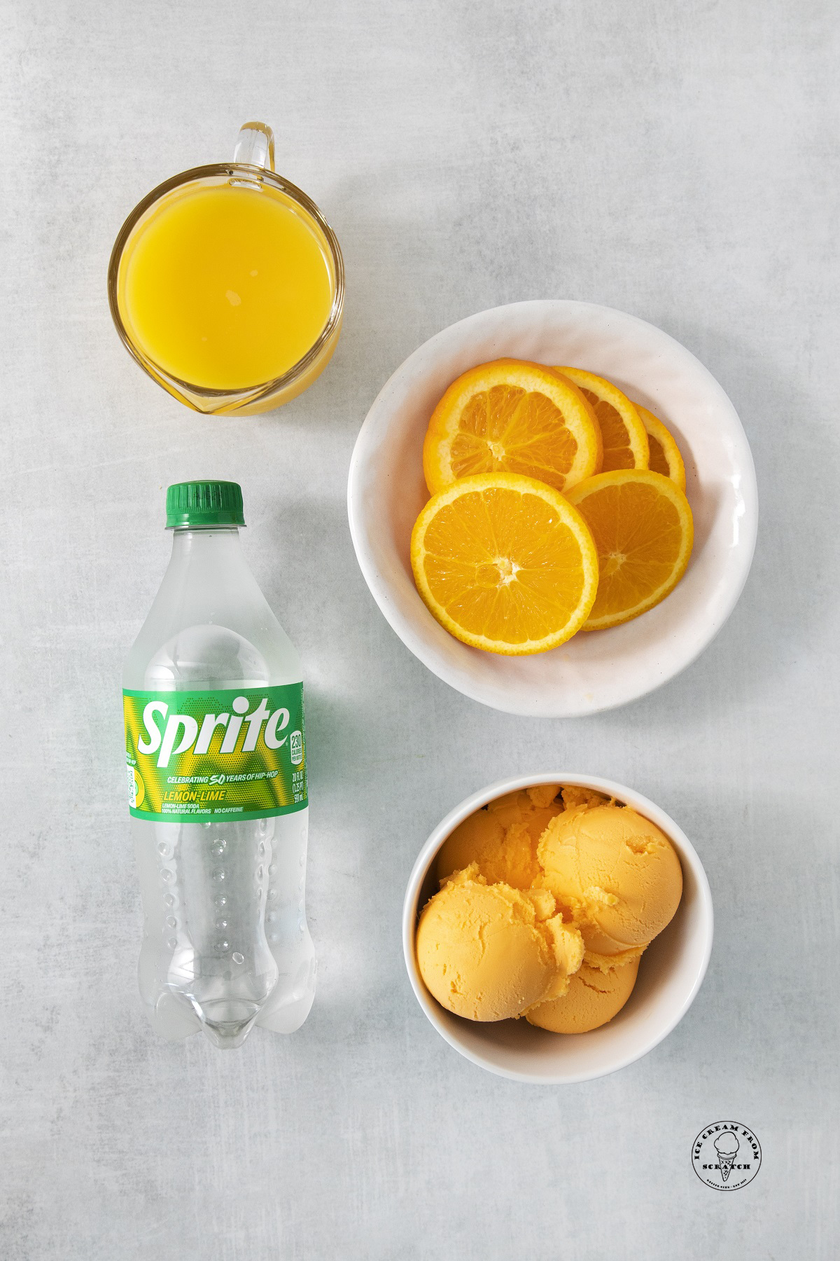 A bowl of sliced oranges, a bowl of orange sherbet, a bottle of sprite, and a cup of orange juice.