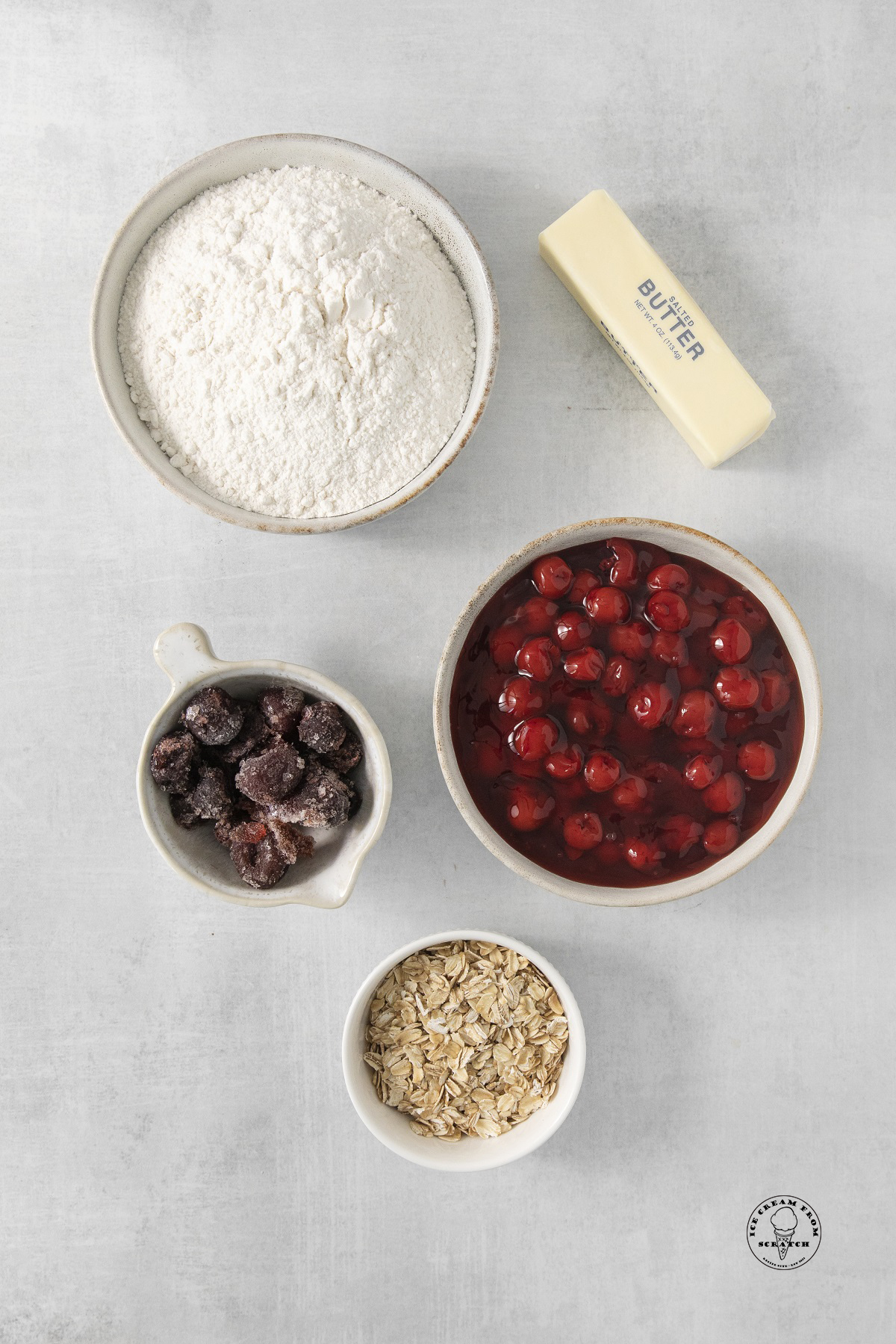 the ingredients needed to make cherry cobbler with cake mix, oats, frozen cherries, and cherry pie filling.