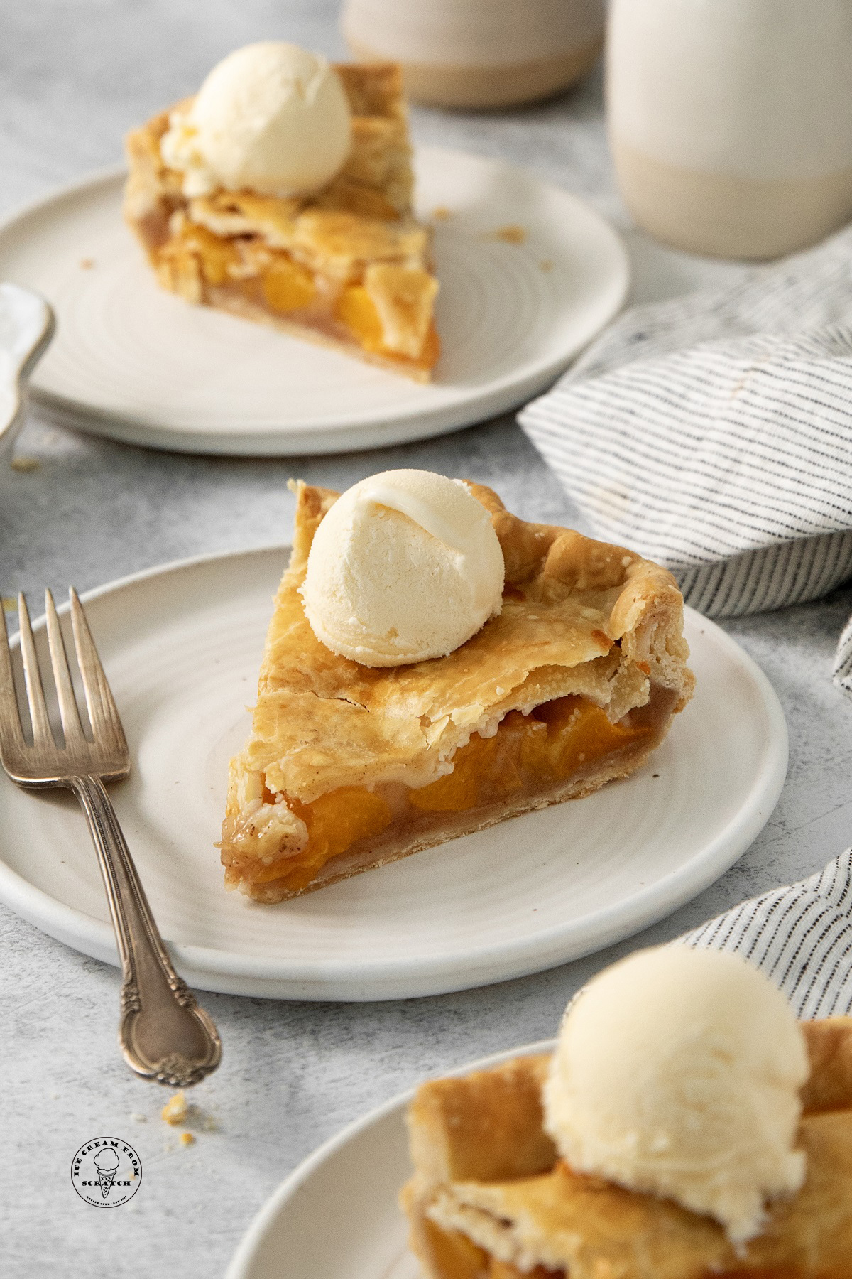 Slices of canned peach pie topped with vanilla ice cream.