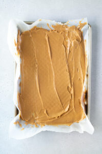 peanut butter spread in a baking sheet for freezing