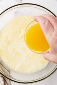 adding orange juice to the custard ice cream mixture