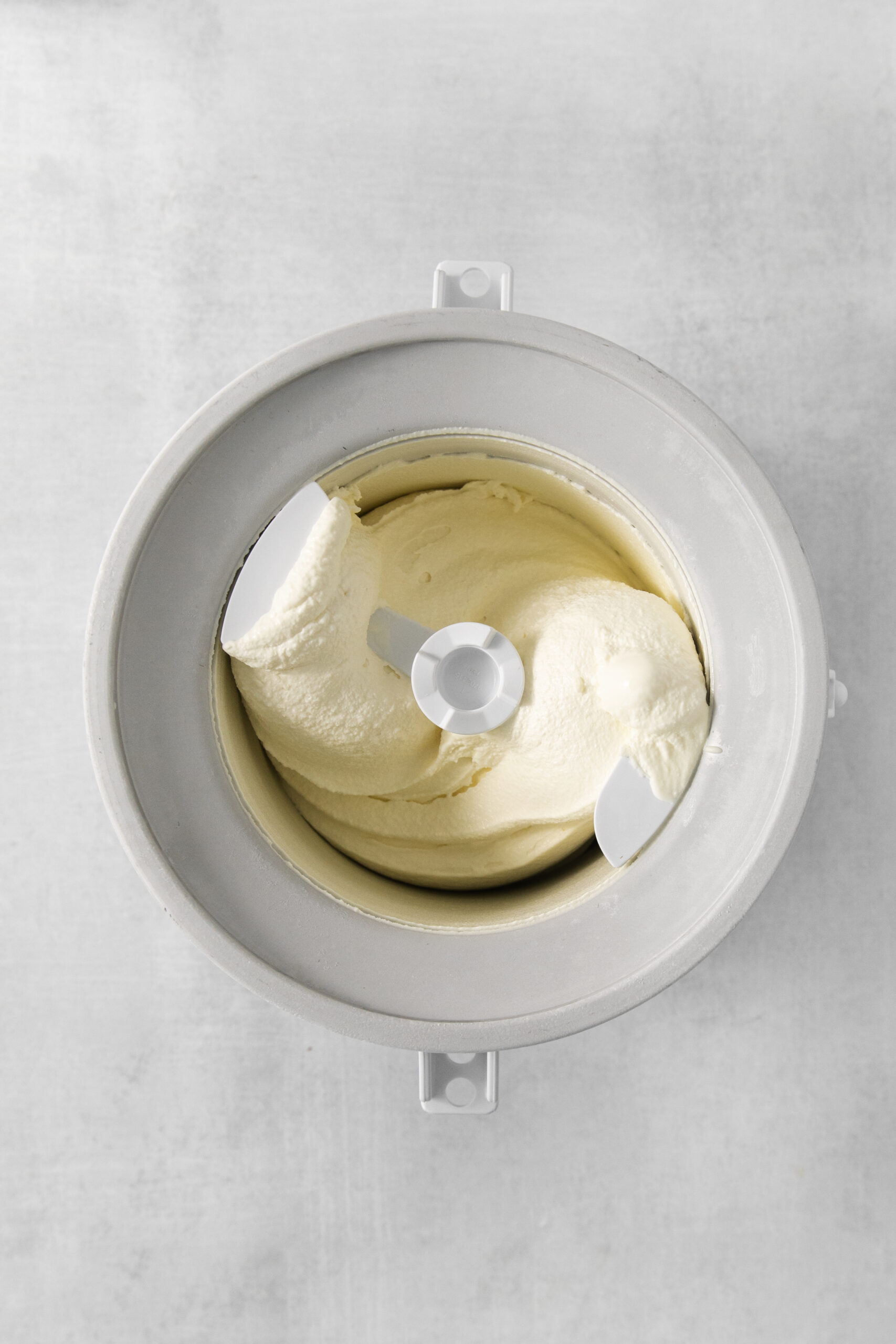 tiramisu ice cream mixture in a ice cream maker bowl
